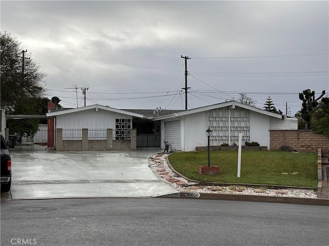 view of front of property featuring driveway, a front lawn, and fence