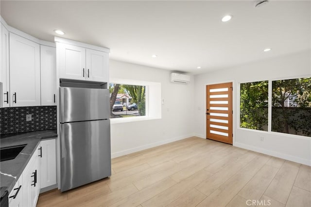 914 N Catalina St, Burbank, CA 91505 - kitchen featuring freestanding refrigerator, a wall mounted air conditioner, dark countertops, backsplash, and white cabinets