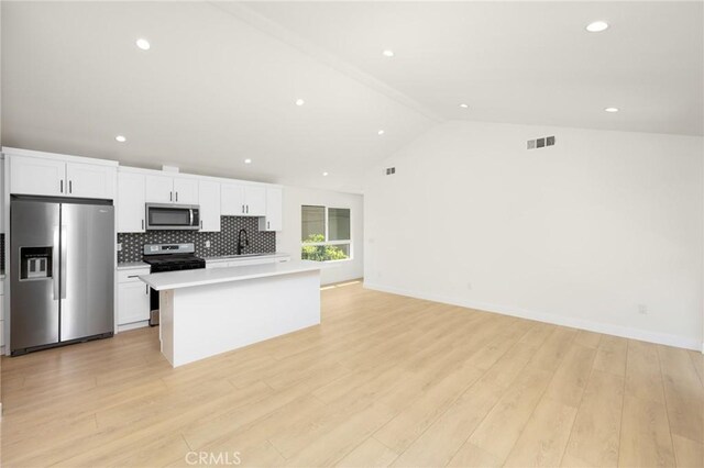 914 N Catalina St, Burbank, CA 91505 - kitchen with appliances with stainless steel finishes, light countertops, white cabinets, a center island, and vaulted ceiling