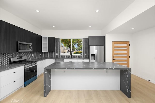 914 N Catalina St, Burbank, CA 91505 - kitchen featuring appliances with stainless steel finishes, modern cabinets, backsplash, a sink, and a breakfast bar