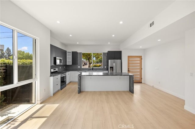 914 N Catalina St, Burbank, CA 91505 - kitchen featuring stainless steel appliances, dark countertops, backsplash, light wood-style flooring, and recessed lighting