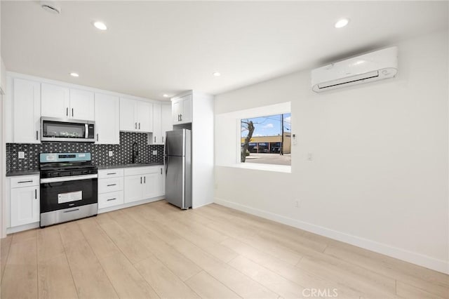914 N Catalina St, Burbank, CA 91505 - kitchen with stainless steel appliances, a wall mounted air conditioner, a sink, baseboards, and backsplash