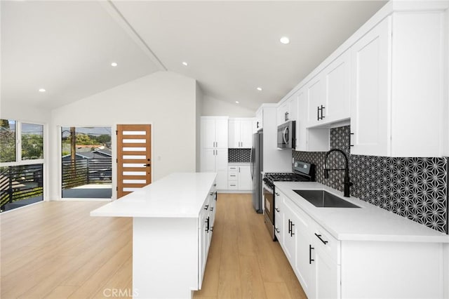 914 N Catalina St, Burbank, CA 91505 - kitchen with appliances with stainless steel finishes, a sink, a center island, light wood-type flooring, and tasteful backsplash