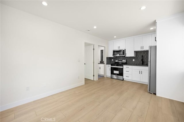 914 N Catalina St, Burbank, CA 91505 - kitchen featuring appliances with stainless steel finishes, light wood-style flooring, white cabinets, backsplash, and recessed lighting