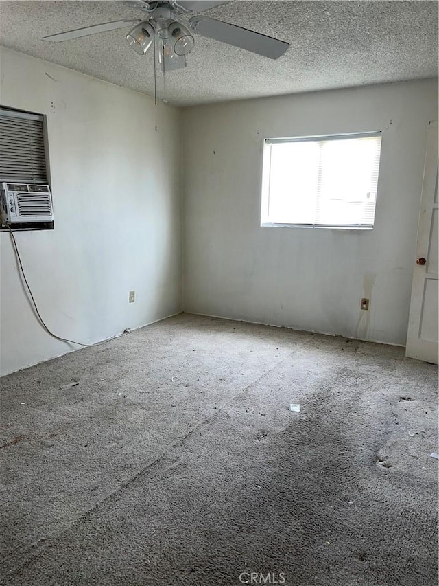 carpeted spare room with cooling unit, a textured ceiling, and a ceiling fan