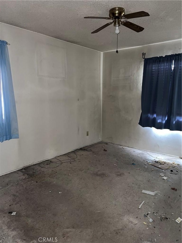 spare room with a textured ceiling and a ceiling fan