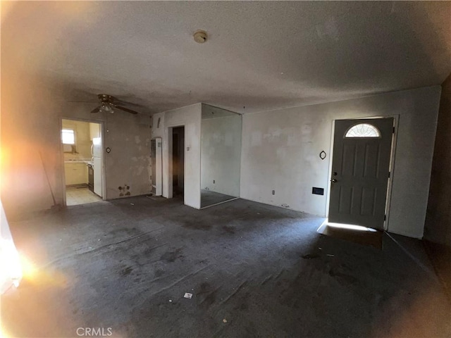 entryway with a wealth of natural light, a textured ceiling, and ceiling fan