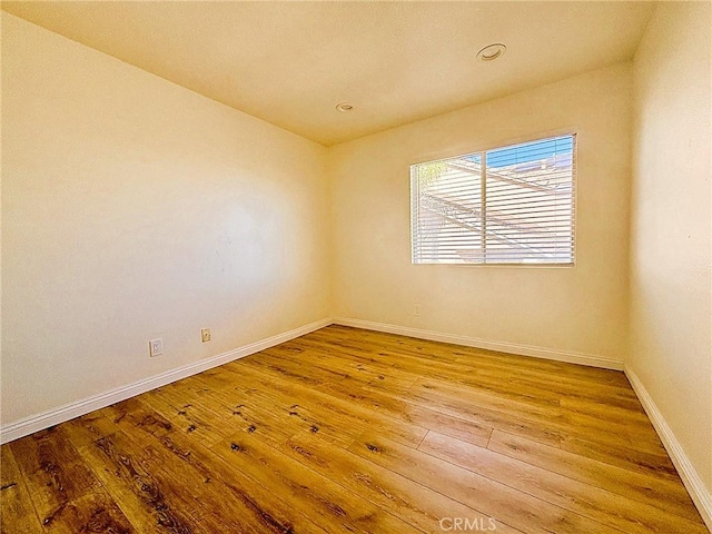 unfurnished room featuring baseboards and hardwood / wood-style floors