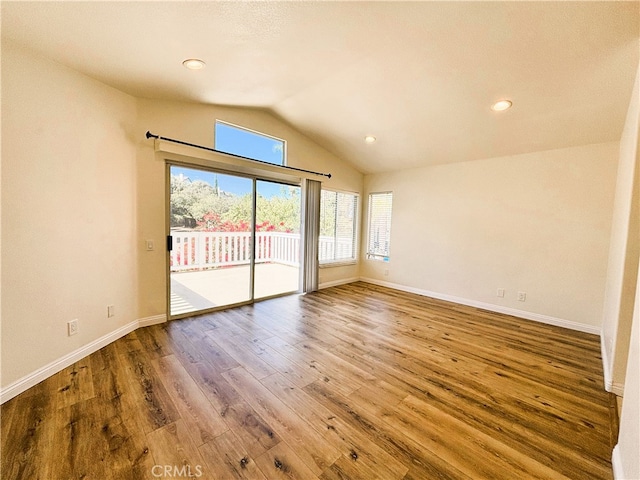 spare room featuring vaulted ceiling, recessed lighting, wood finished floors, and baseboards