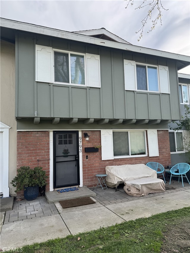 entrance to property featuring brick siding and a patio