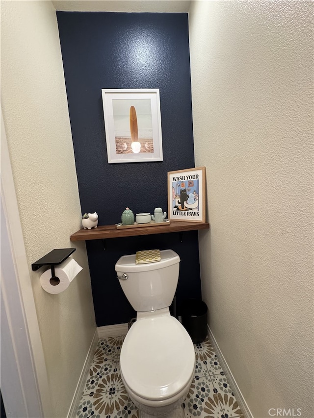 bathroom with tile patterned flooring, toilet, and baseboards