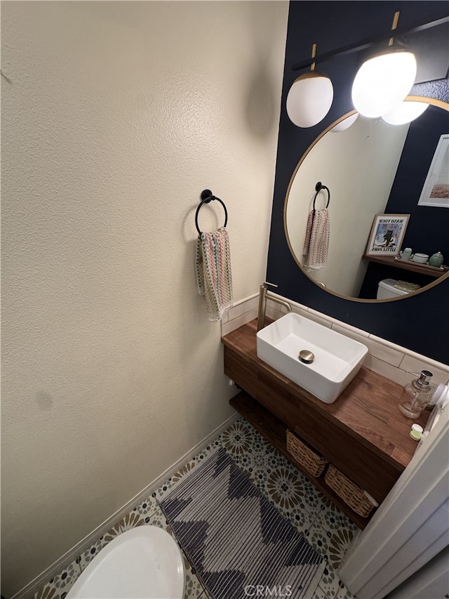 half bath featuring a sink and baseboards