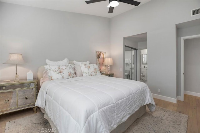 bedroom with visible vents, a ceiling fan, ensuite bathroom, wood finished floors, and baseboards