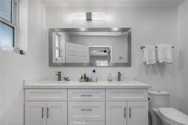 full bath with a wealth of natural light, toilet, and a sink