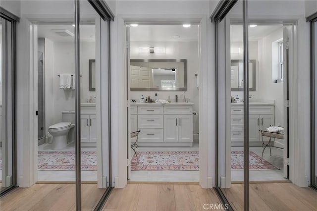 bathroom with toilet, vanity, and hardwood / wood-style flooring