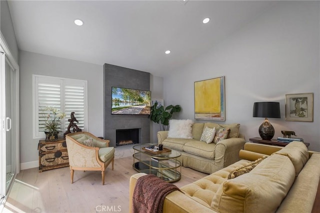 living room featuring a large fireplace, baseboards, light wood-type flooring, lofted ceiling, and recessed lighting