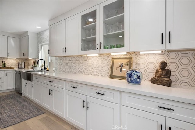 kitchen featuring white cabinets, dishwasher, and light countertops