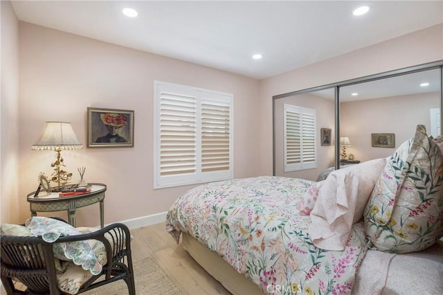 bedroom featuring a closet, recessed lighting, baseboards, and light wood-style floors