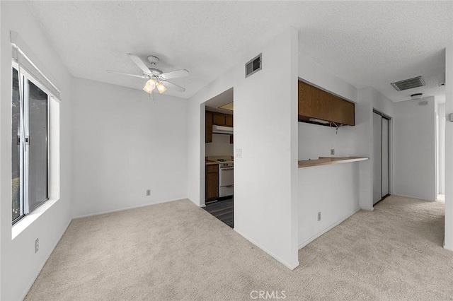 unfurnished room featuring visible vents, carpet floors, and a textured ceiling