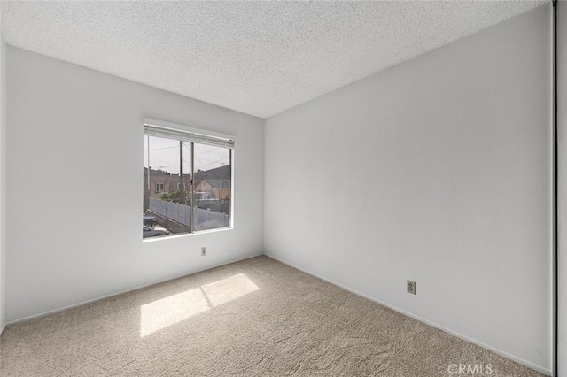 carpeted spare room featuring a textured ceiling