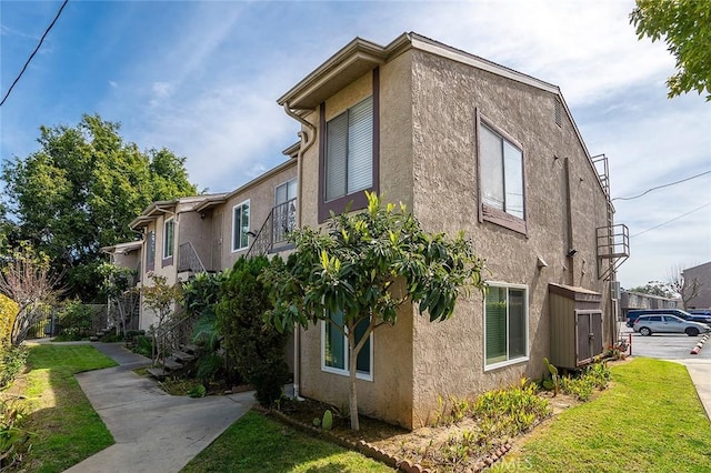 view of property exterior featuring a lawn and stucco siding