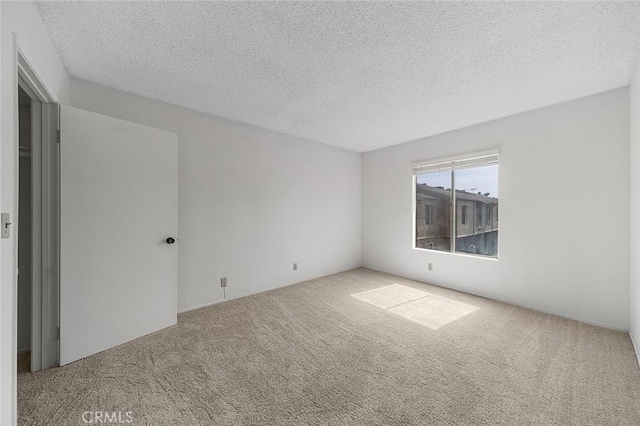 spare room with a textured ceiling and carpet