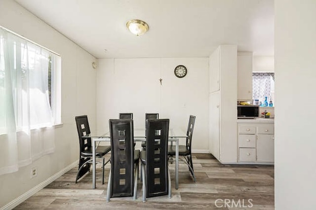 dining area with wood finished floors and baseboards