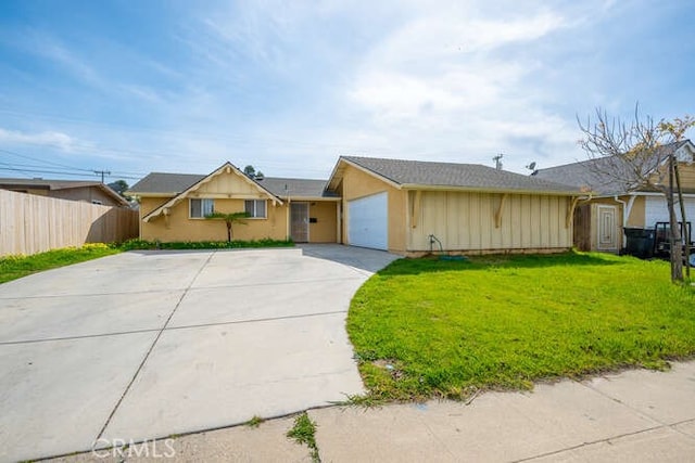 ranch-style home featuring concrete driveway, an attached garage, fence, and a front lawn