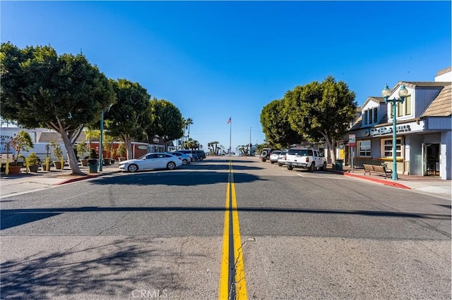 view of road with street lights, curbs, and sidewalks