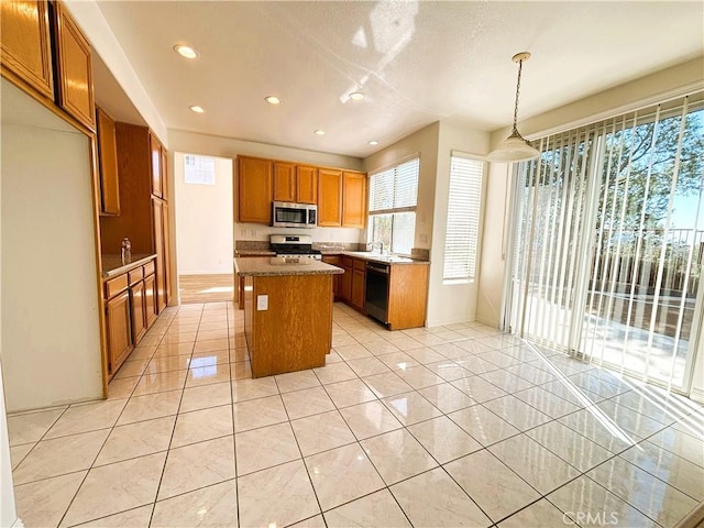 kitchen with brown cabinets, a kitchen island, recessed lighting, appliances with stainless steel finishes, and light tile patterned floors