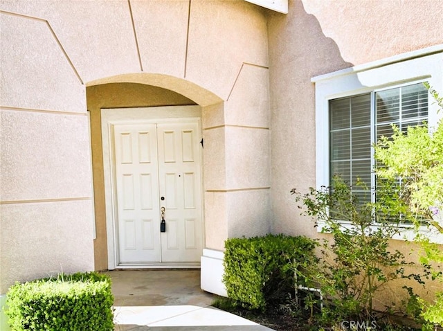 doorway to property featuring stucco siding