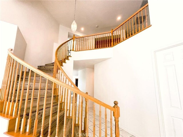 stairs featuring recessed lighting and a towering ceiling