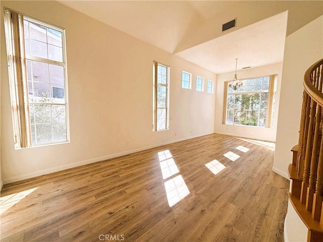 interior space with visible vents, a notable chandelier, light wood-style floors, and baseboards