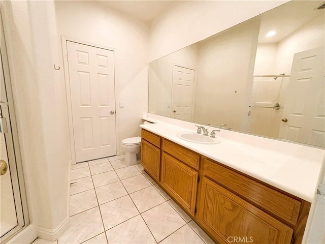 bathroom featuring vanity, a shower stall, toilet, and tile patterned flooring