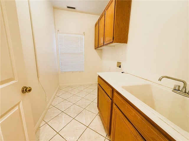 bathroom featuring tile patterned flooring, visible vents, baseboards, and a sink