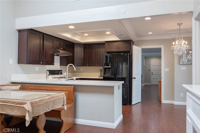 kitchen with a sink, dark brown cabinetry, a peninsula, and black refrigerator with ice dispenser