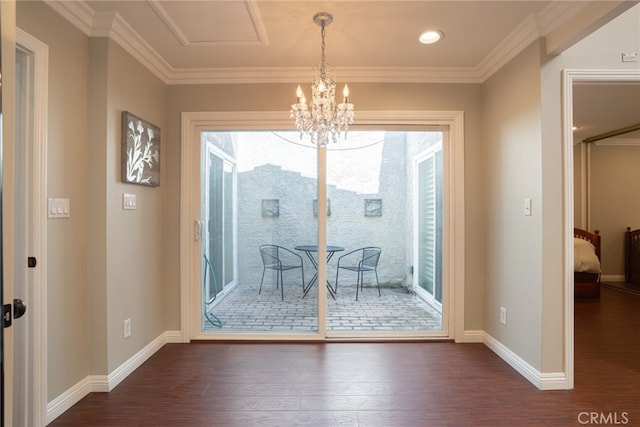 unfurnished dining area featuring baseboards, a notable chandelier, ornamental molding, and dark wood-style flooring