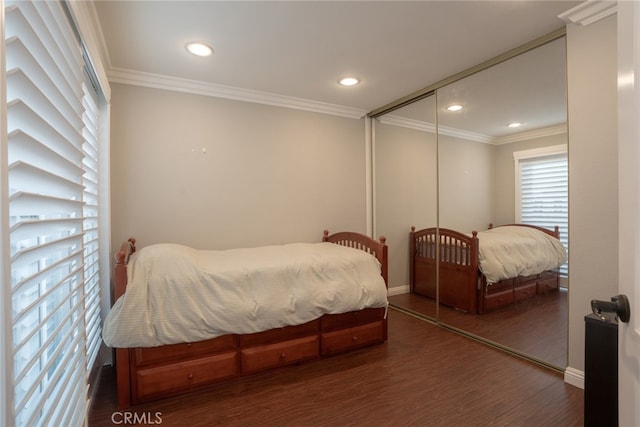 bedroom with baseboards, ornamental molding, recessed lighting, wood finished floors, and a closet