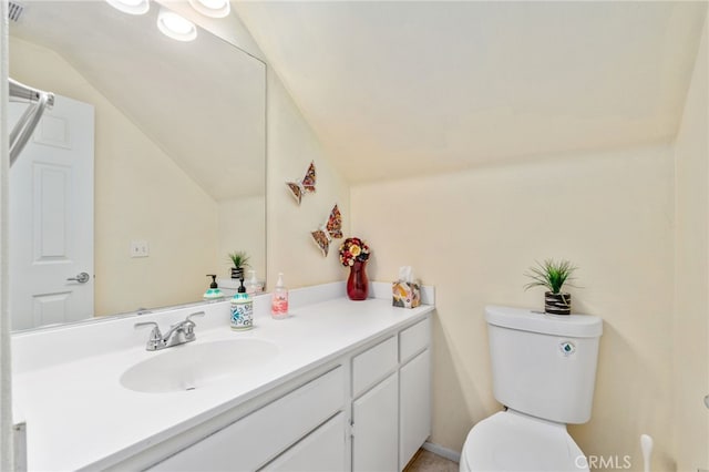 bathroom with lofted ceiling, toilet, and vanity