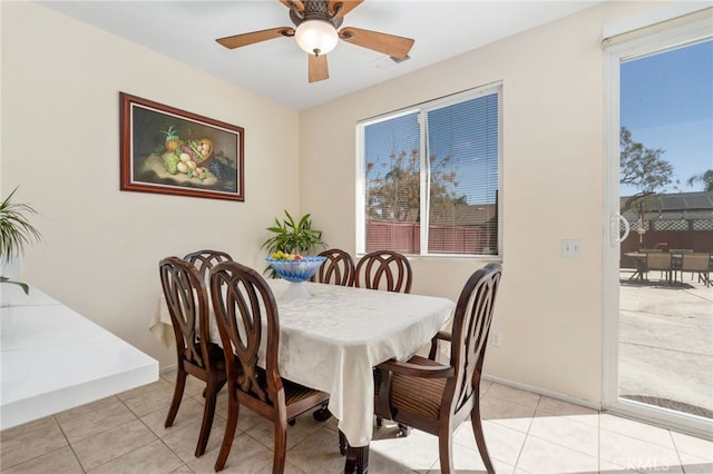 dining area with light tile patterned flooring, baseboards, and a ceiling fan