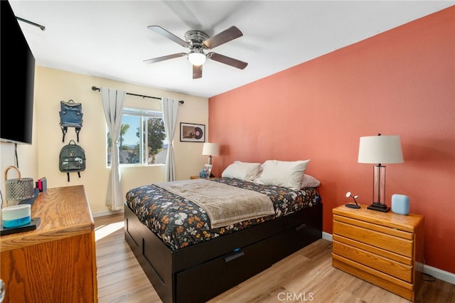 bedroom featuring light wood-style flooring, baseboards, and ceiling fan