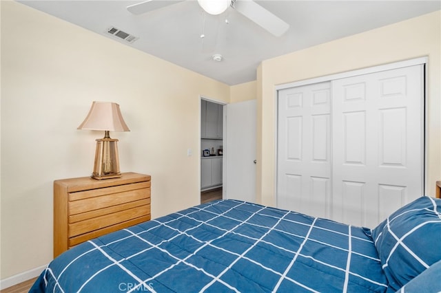 bedroom with visible vents, baseboards, wood finished floors, a closet, and a ceiling fan