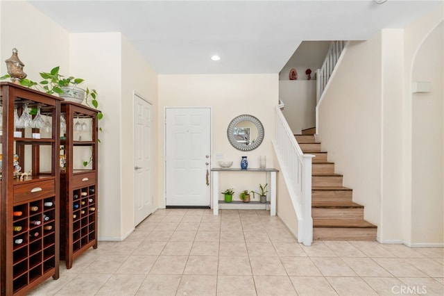 foyer entrance featuring stairs, light tile patterned floors, recessed lighting, and baseboards