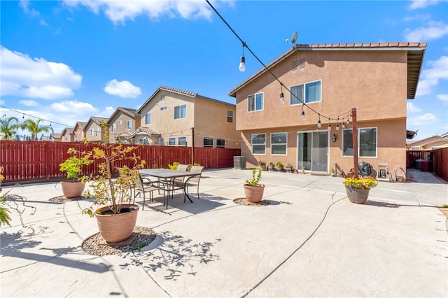 back of property featuring stucco siding, central AC, a fenced backyard, and a patio area