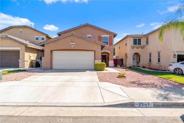 mediterranean / spanish home with an attached garage, driveway, and stucco siding