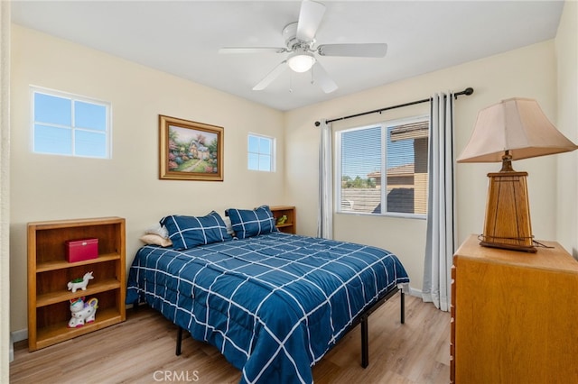 bedroom with baseboards, a ceiling fan, and wood finished floors