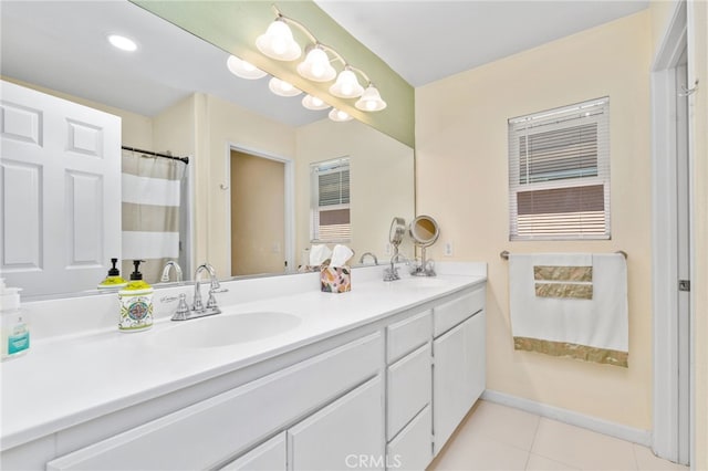 bathroom featuring tile patterned floors, double vanity, baseboards, and a sink