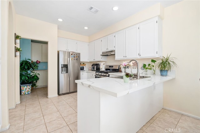 kitchen with visible vents, under cabinet range hood, appliances with stainless steel finishes, a peninsula, and light tile patterned flooring