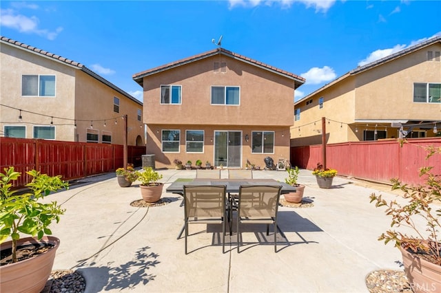 back of property with a patio area, stucco siding, and a fenced backyard