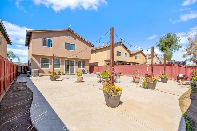 rear view of property with a patio area, a fenced backyard, and stucco siding